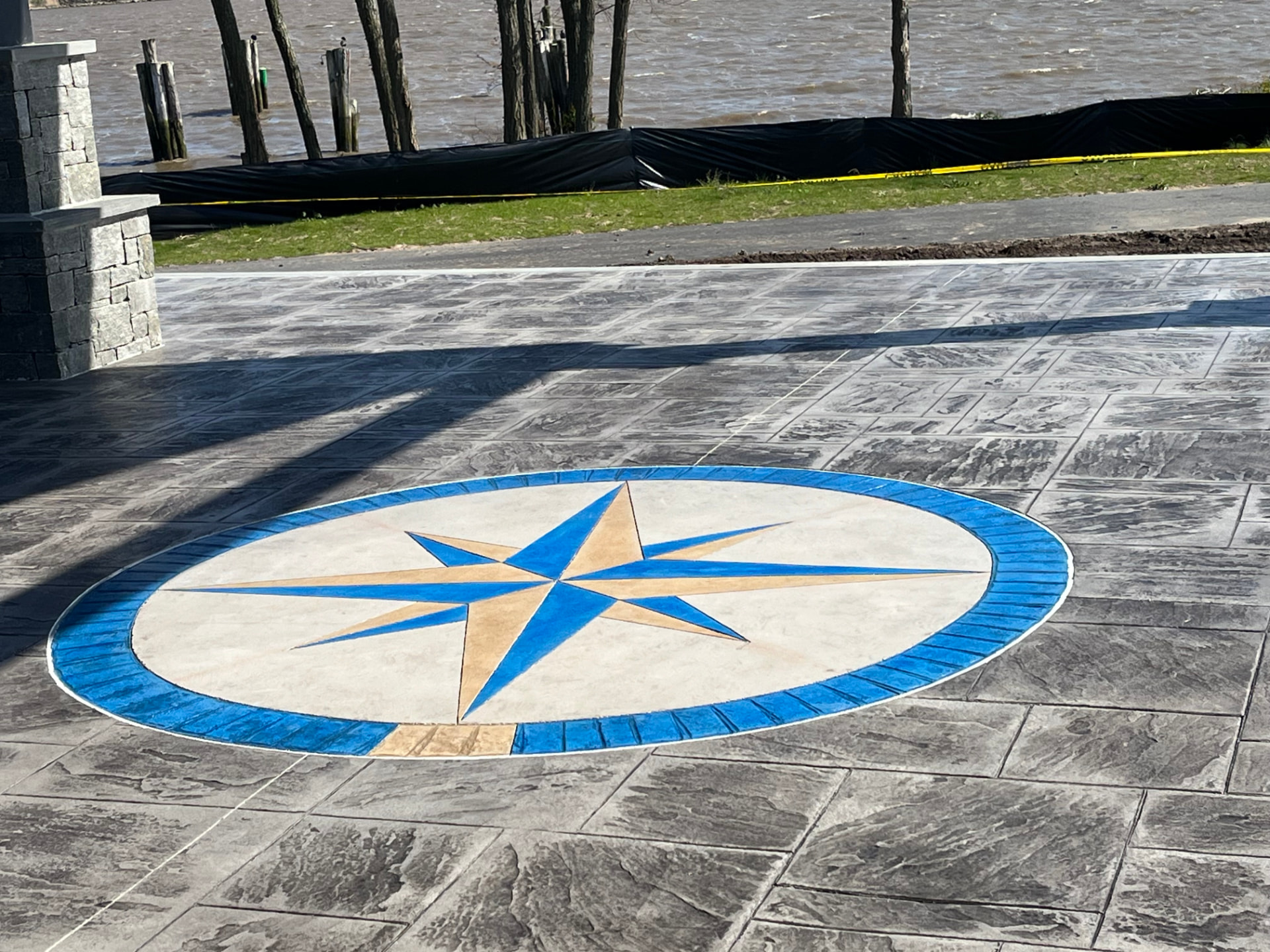 Blue and tan compass rose inlay in stamped concrete patio