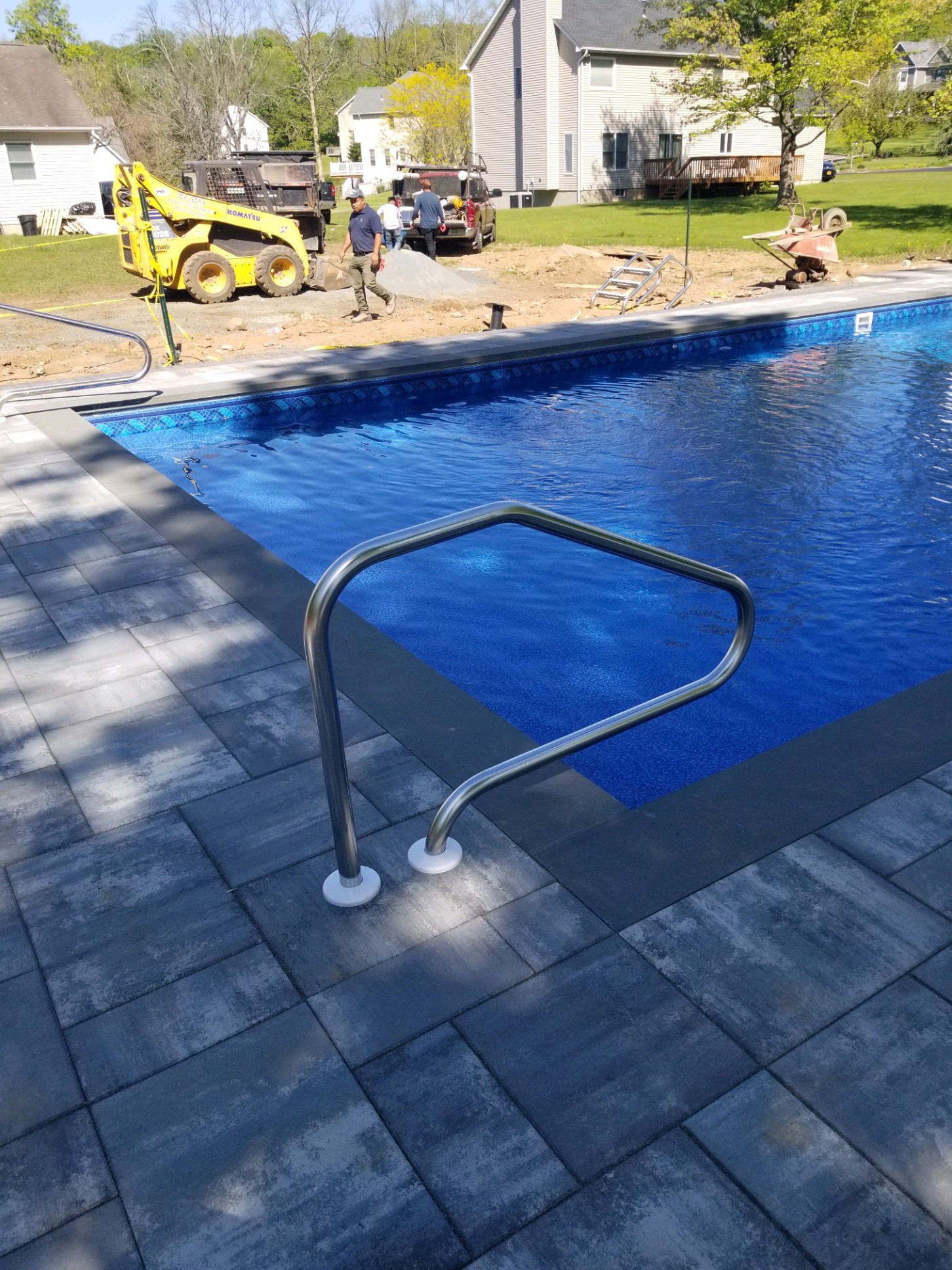 In-ground pool with charcoal paver deck