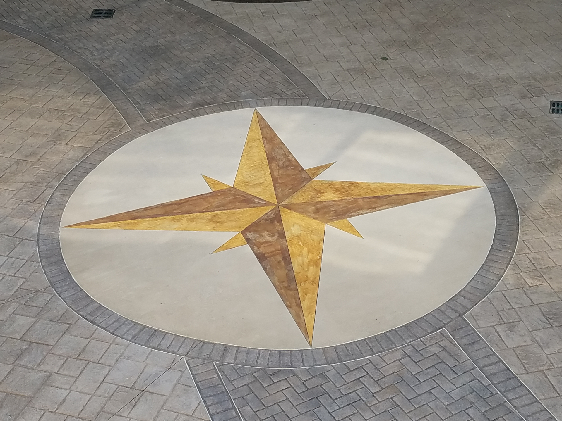 Gold compass rose stamped concrete detail