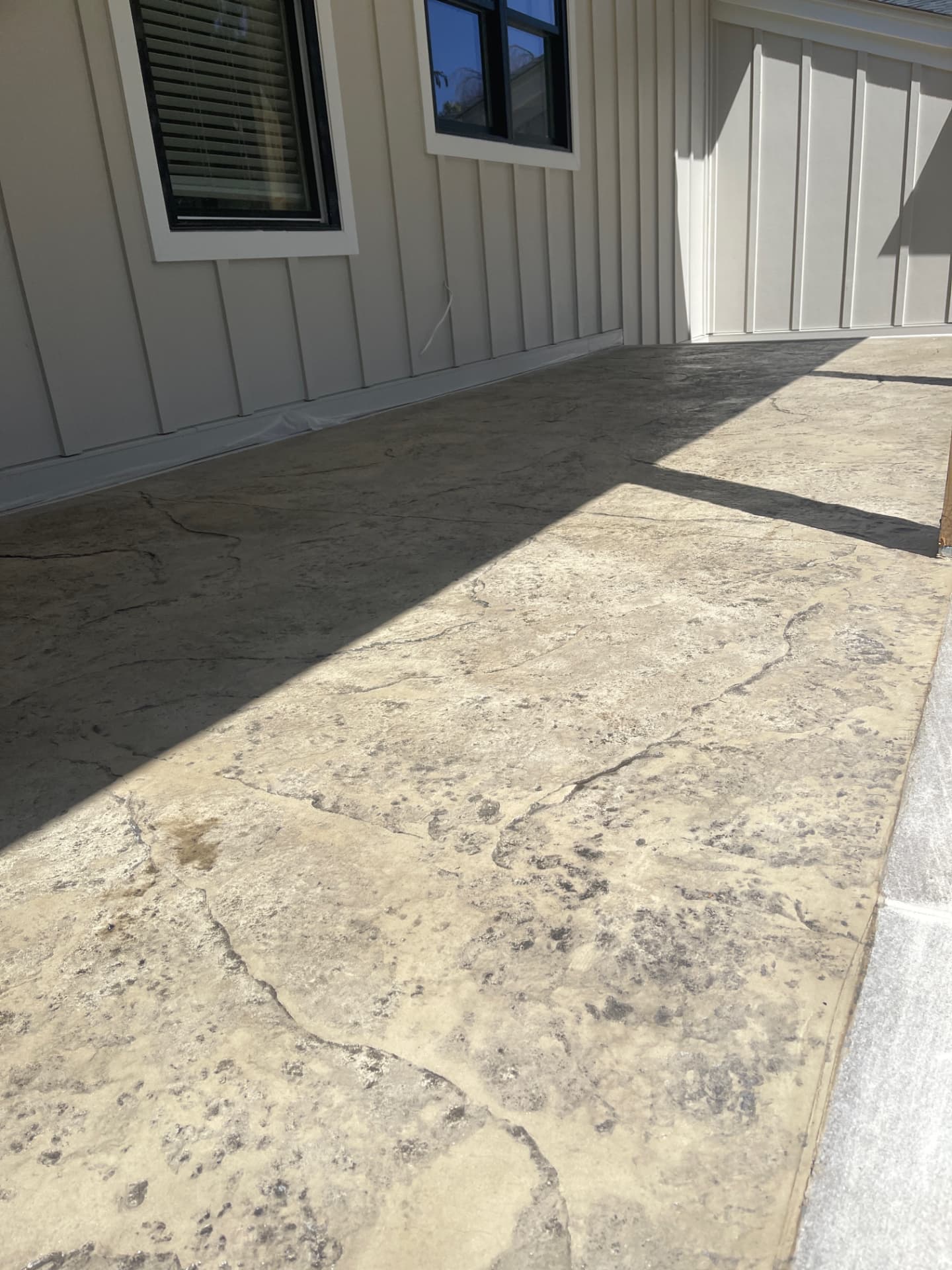 Tan seamless stone stamped concrete patio beside a home