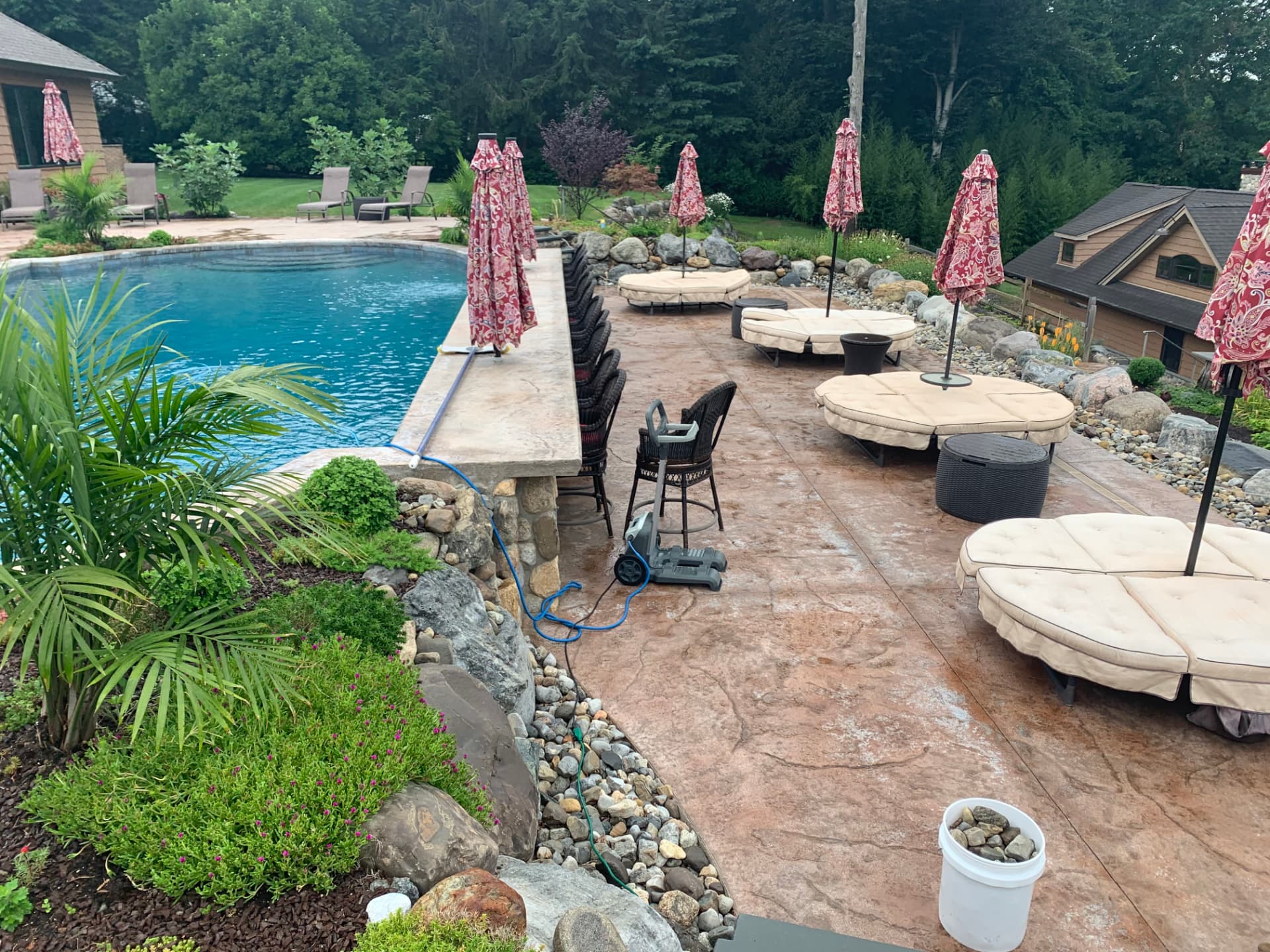 Stamped concrete pool deck with a stone swim-up bar and lounge seating