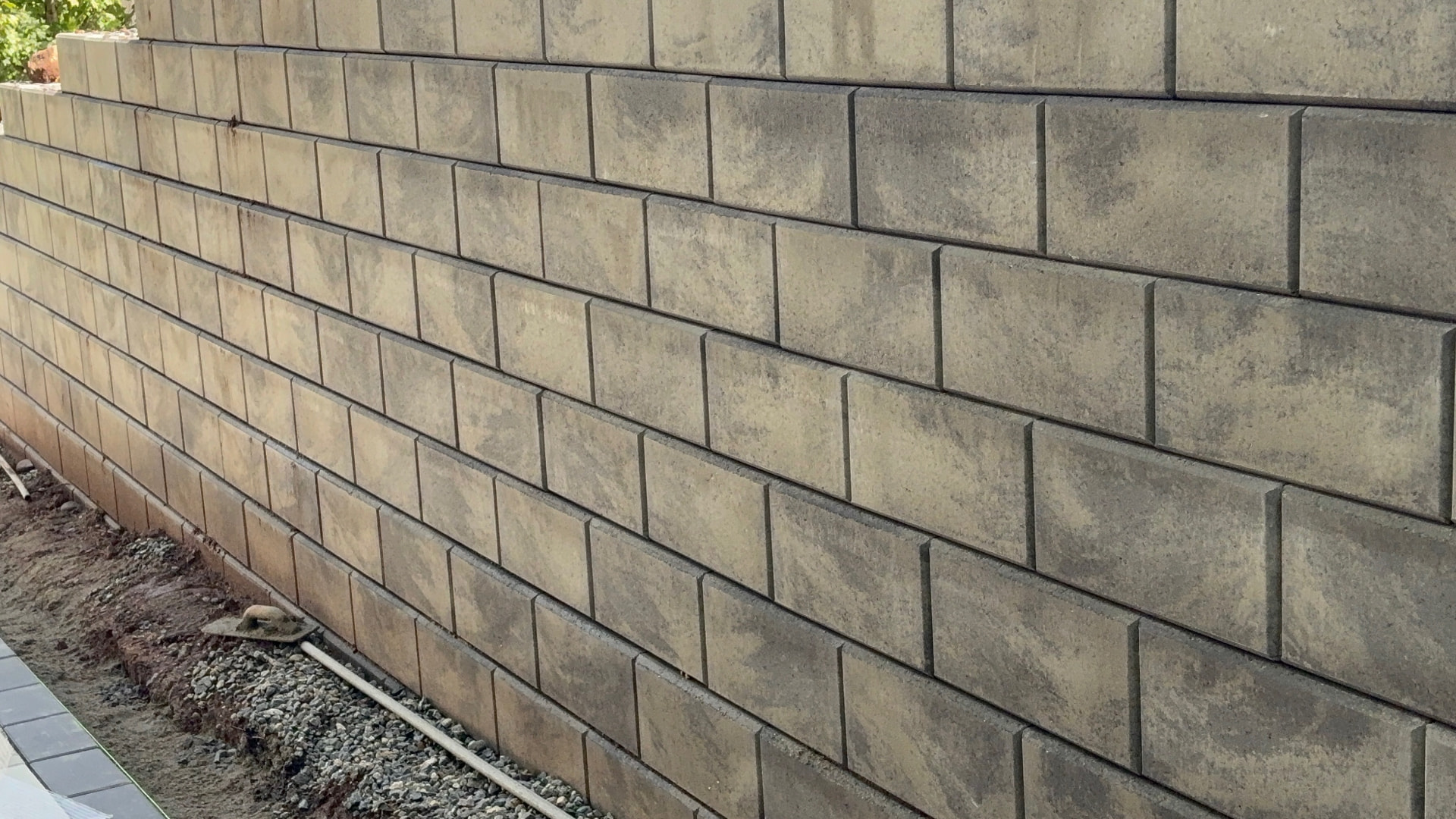 Close-up of tan segmental block retaining wall coursing