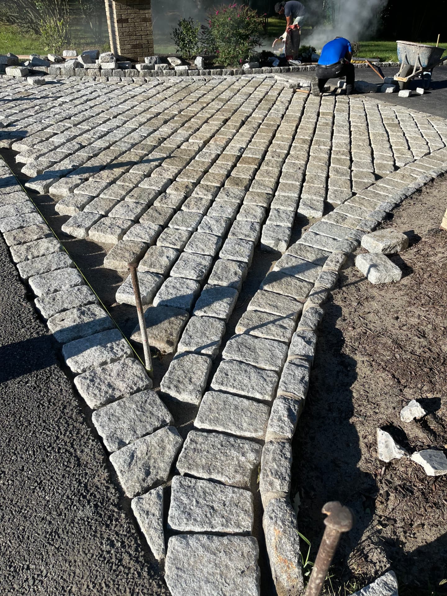 Granite cobblestone driveway apron being installed